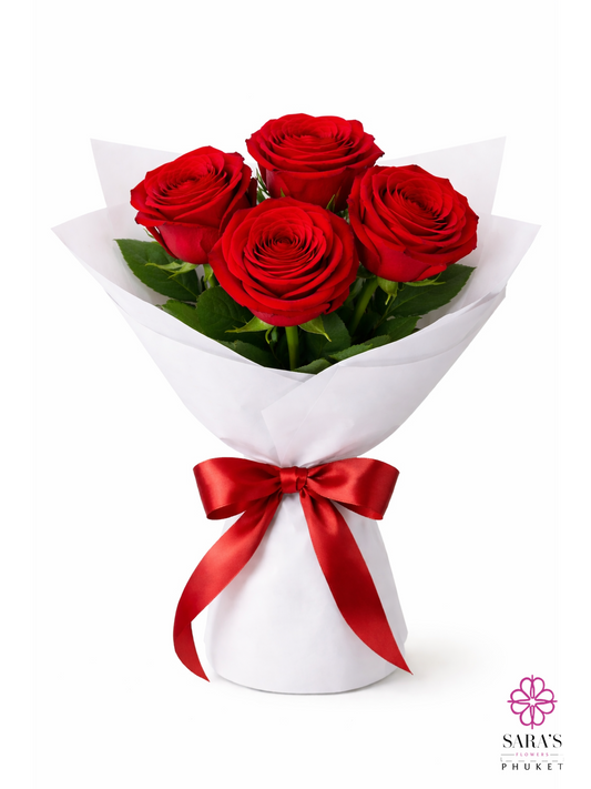Four long-stem red roses in a luxury white paper wrap with a red satin ribbon by Sara's Flowers Phuket.