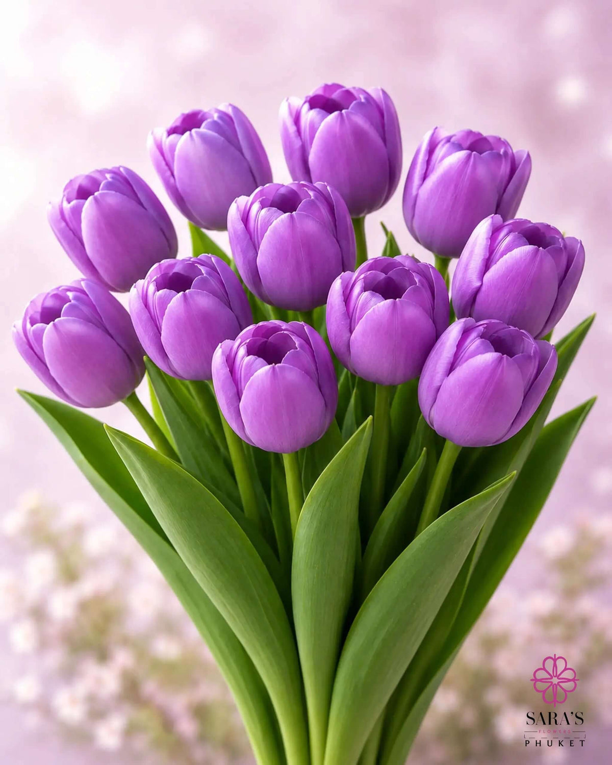 Elegant bouquet of fresh purple tulips with green stems, against a soft, blurred light background.