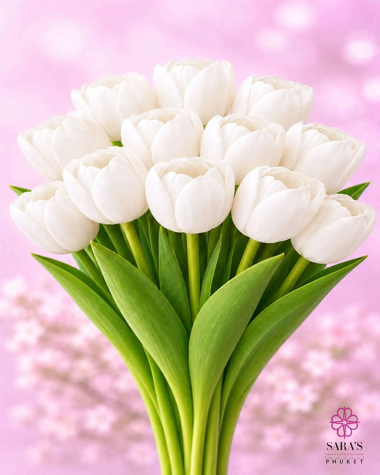 Elegant Sara's Signature Tulip Bouquet with premium white tulips, green stems, against a soft pink background.