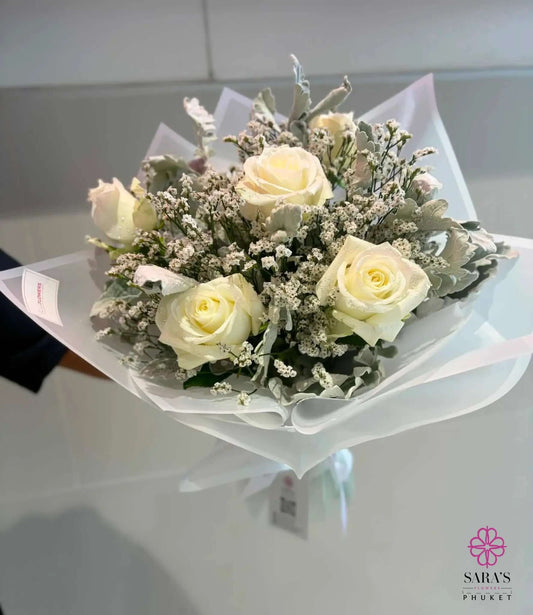 Bouquet of white roses with baby's breath on a white background
