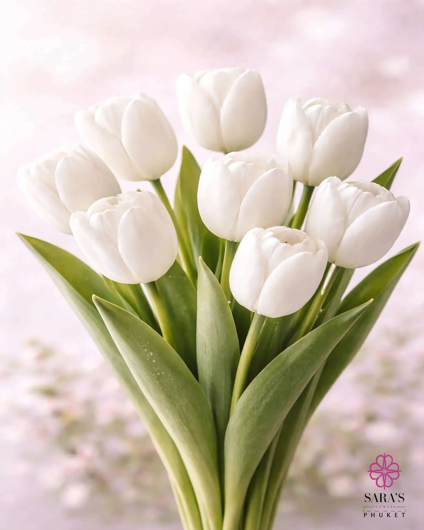 Elegant Sara's Signature Tulip Bouquet with nine fresh white tulips and green leaves, wrapped in luxury white paper.