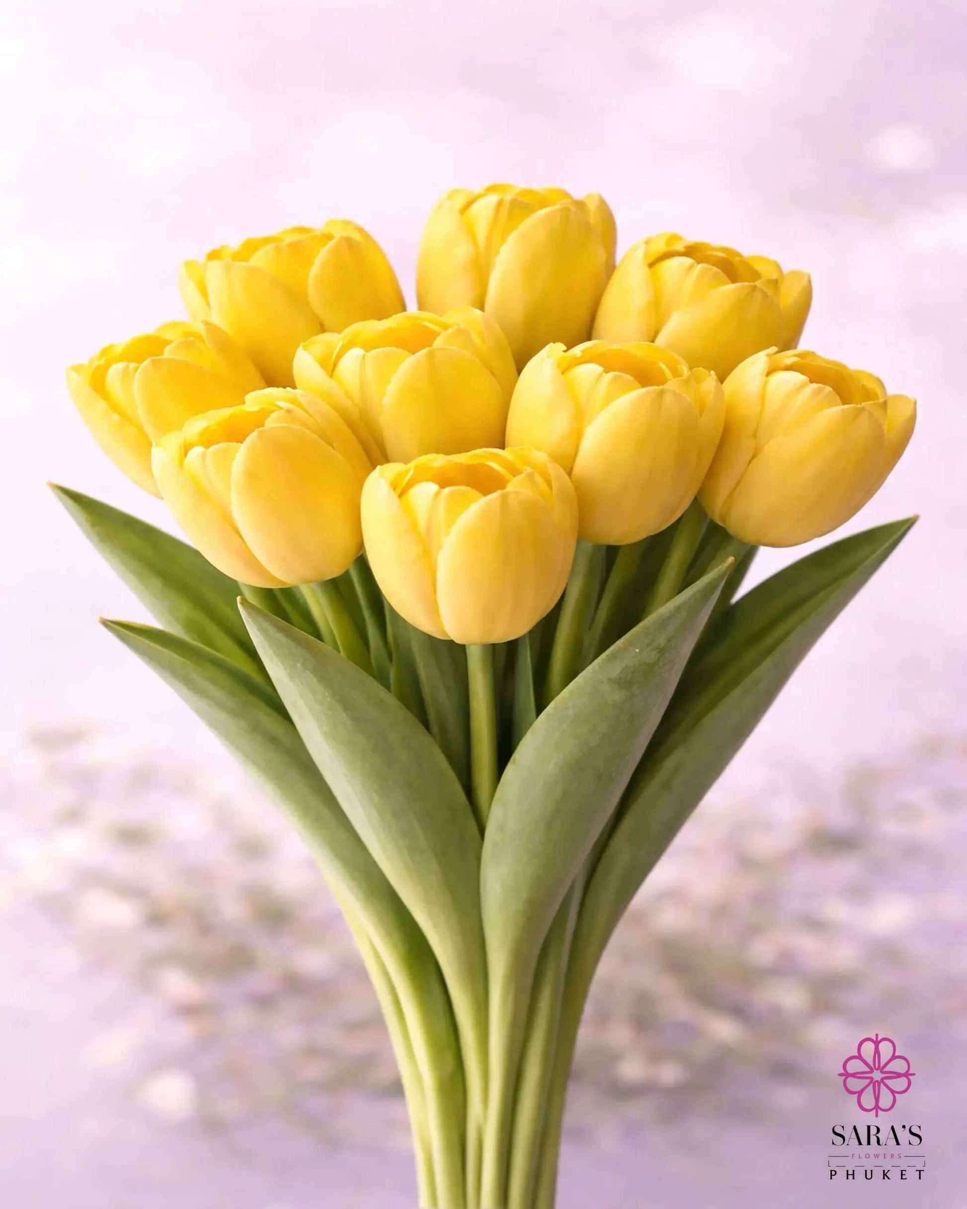 Vibrant yellow tulip bouquet with green stems, elegantly arranged against a soft background.