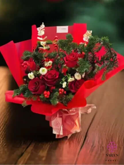Luxury red rose bouquet with lush greenery and dramatic red wrapping by Sara’s Flowers Phuket