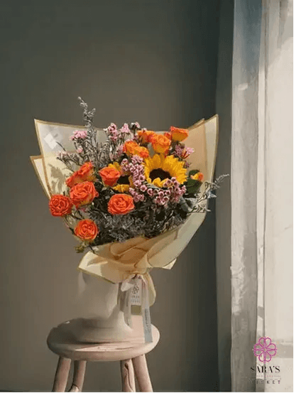 Bright sunflower and orange rose bouquet with yellow wrapping by Sara’s Flowers Phuket