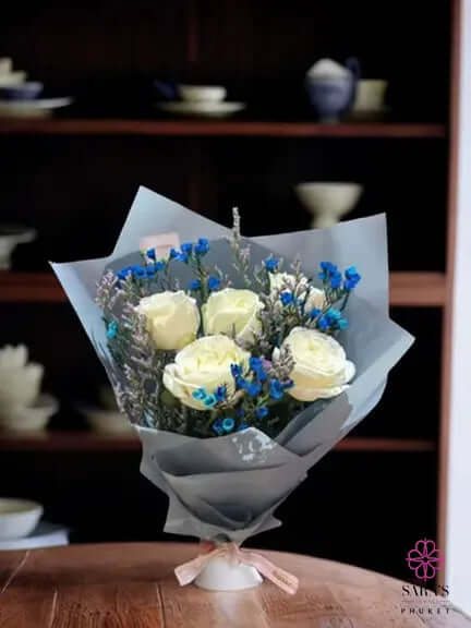 White rose bouquet with blue statice in elegant grey-blue wrapping by Sara’s Flowers Phuket