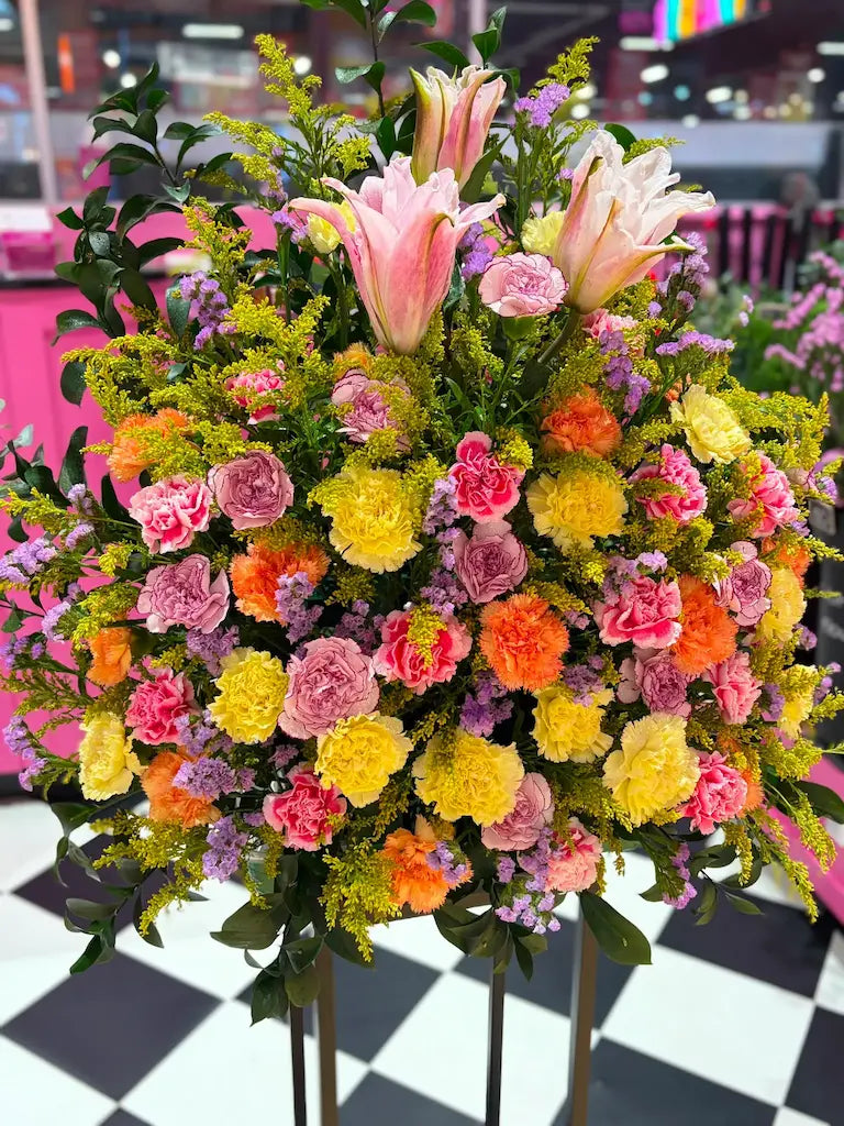 Close-up of Sunrise Serenade flower arrangement featuring pink lilies, carnations, statice and solidago