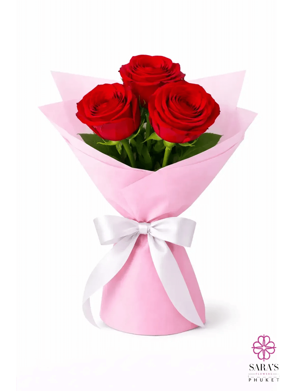 Three vibrant red roses in a luxury pink paper bouquet with a white satin ribbon, by Sara’s Flowers Phuket.